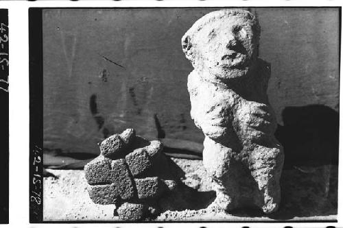 Stone figure of person and pad of stone shaped as jaguar foot