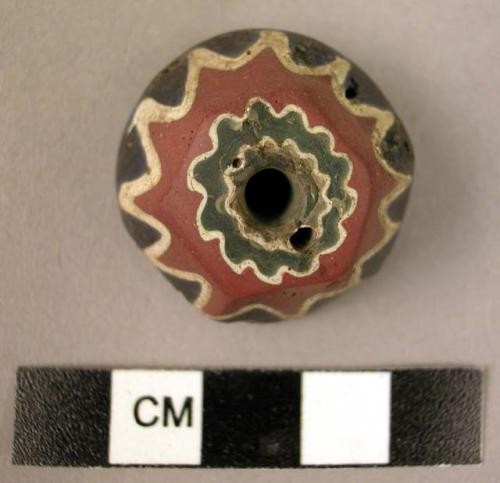 Fragment of a large glass bead with millifiore decoration