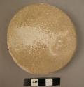 Large circular linestone disc - probably grinding stone