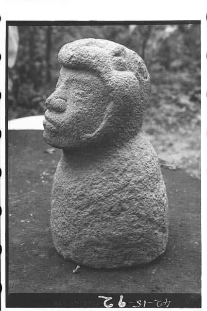 Stone sculpture human head in bird's beak