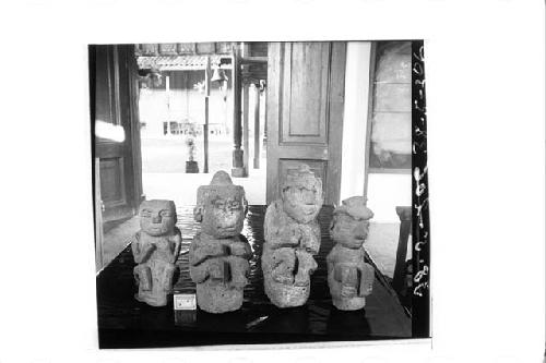 Four small stone statues