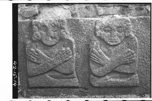 Stone slab with 2 seated figures with arms crossed over breast