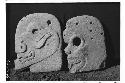 2 flat stone heads  on right human