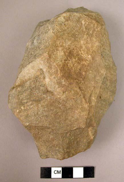 Crude quartzite fist axe made from natural stone with weathered surfaces