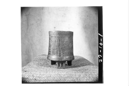 SAA 11 - black, incised tripod vase. hright 17 cms.