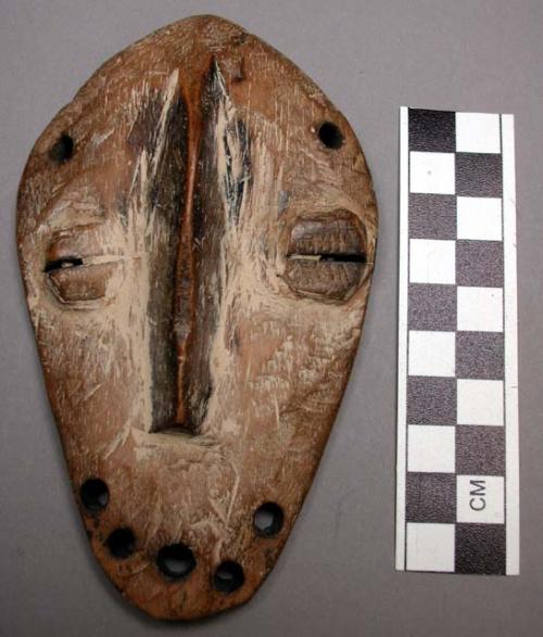 Bwami society maskette, kindi grade, with large holes for beard, kaolin traces.