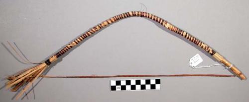 Bow used for ceremonial purposes in a dance, strips of grass held in place by sm