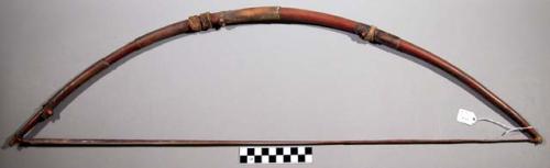 Wooden bow decorated with pieces of fur and skin from antelope legsm fibre bow s