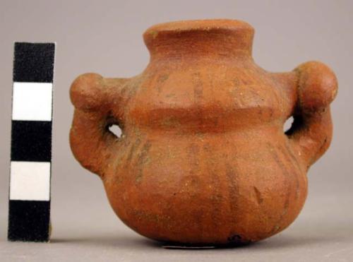 Miniature red vessel with black line design.  2 stylized beakbird effigy heads