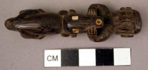 Small carved wood figure of a man opening the jaws of an alligator (?)