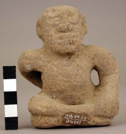 Stone figure of seated person "scrubbing" (?) back.