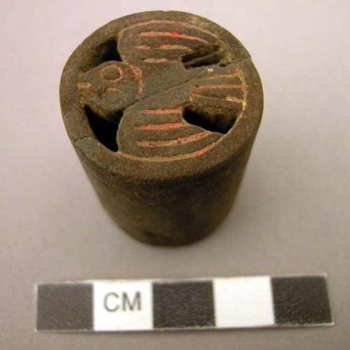 Wooden ear plug with carved design of a bird