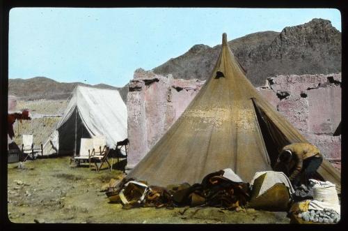 Lantern slide of tents by building ruins, hand-colored