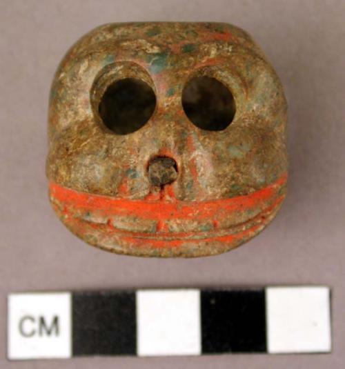 Carved skull of gray green stone - traces of vermillion coloring