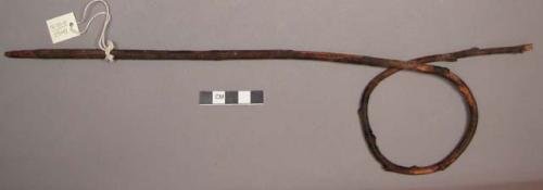 Wood, Prayer stick, pointed at one end, formed into a loop near top, charred