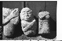 3 stone figures with arms crossed on breast; two headless