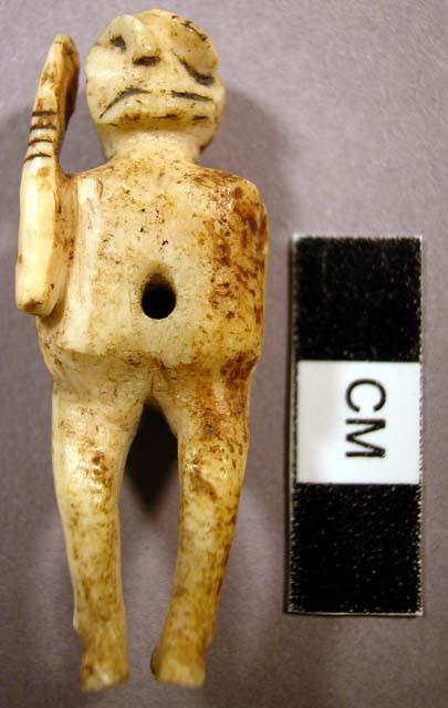 Carving of human figure, ivory. Asymmetrical eyes; nose and eyes distorted.