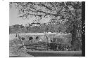 Men resting in the shade next to the old bridge