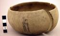 Broken gourd bowl with few incised designs on bottom