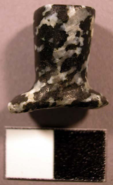 Ground syenite labret. Head is oval-shaped, flared, and concave.