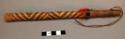 Short wooden stick with small red feathers at top - ceremonial