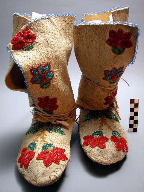 Pair of skin moccasins with floral design of beading with short legging