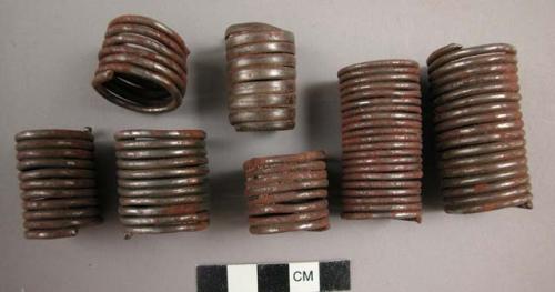 Ornaments, iron spiraled tubes, possibly large beads to a necklace