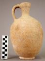 Pinch-spouted, narrow-necked pottery pitcher; low solid; 2 strip handle with riv