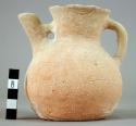 Narrow neck pottery pitcher with bridged side spout and rolled handle