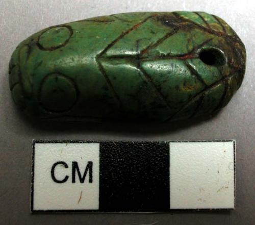 Scratcher, of green stone, with fish