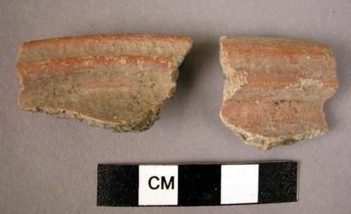 2 potsherds - shiny red painted? outside & inside; rim sherds