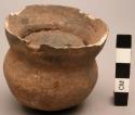 Wide-mouthed pottery vessel containing clay-like substance