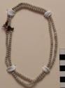 Necklace, small white beads with single pink bead, olunigi lwomukala