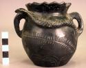 Small black pottery vessel with two handles and modelled snake on side