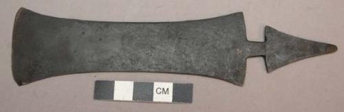 Flat metal blade, one end is a flaring rectangle and the other, separated by a t