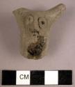 Plain grey ware handle fragment with decoration of a face