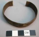 Incised brass bracelet with decorations