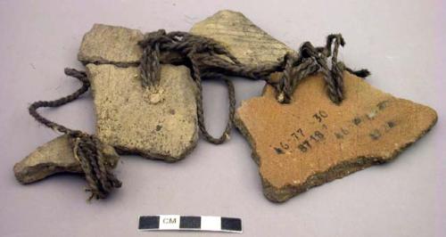 5 clay potsherds, pierced and strung together with heavy twine