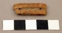 Ground stone bead, rectangular, grooved, four holes