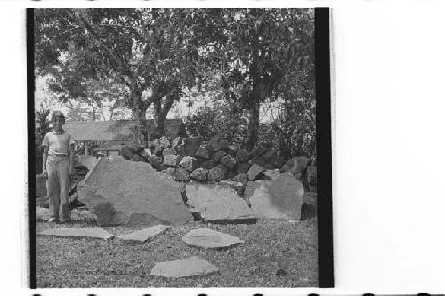 Boy next to stone slabs from fill of mound