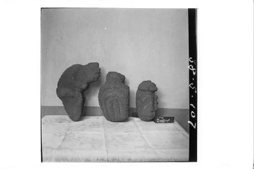 Three crude stone figures.