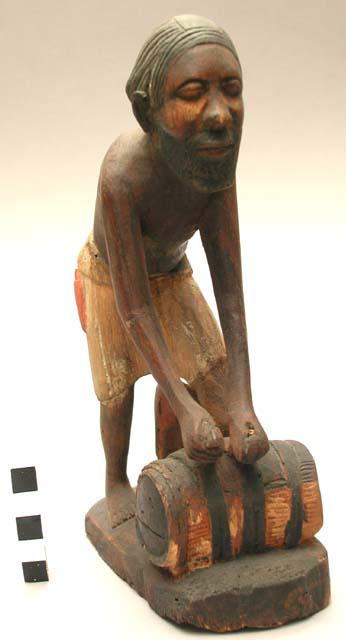 Wood carving of native hunter preparing a beehive