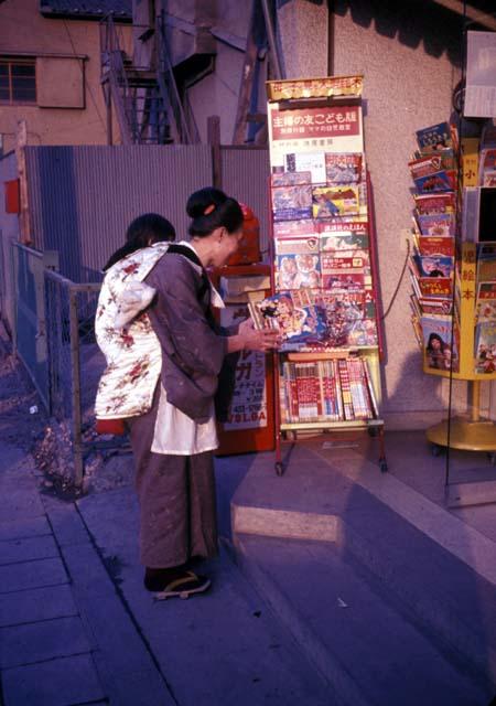 Mother with child on back at magazine stand, Tokyo