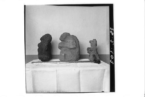 Three crude stone figures (left profile).