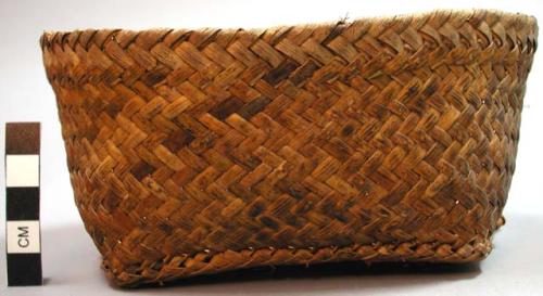 Basket, woven fiber, oval with squared base, loops at ends of base