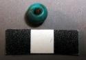 Bead, round, blue glass, fiber lodged in perforation
