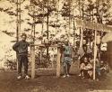 Men standing by and sitting near head of decapitated man