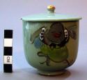Bluish green covered porcelain tea cup and lid with painted decorations
