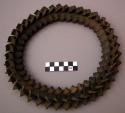 Ornament, interlocking carved wood pieces forming flexible ring, dark brown