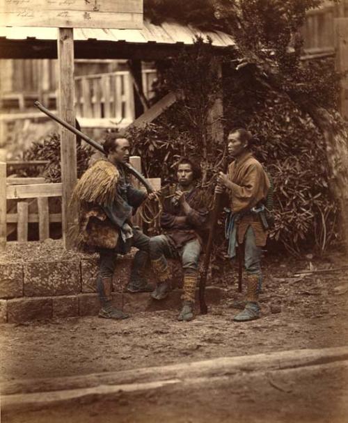 Two Japanese men with guns, one with a pipe
